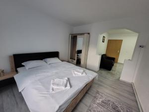 Un dormitorio con una gran cama blanca con dos almohadas. en Vila ZENARA, en Pucioasa