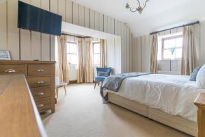 a bedroom with a bed and a dresser and windows at Glenvela guest house in Castlerea