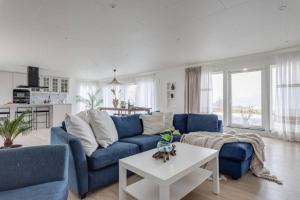 a living room with a blue couch and a table at Captivating 3-Bed Villa in Halanda with Lake View in Sandåker