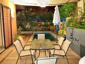 eine Terrasse mit einem Tisch und Stühlen sowie einem Pool in der Unterkunft 3 bedrooms villa with private pool enclosed garden and wifi at Marrakech in Aït Ali