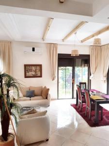 ein Wohnzimmer mit einem Sofa und einem Tisch in der Unterkunft 3 bedrooms villa with private pool enclosed garden and wifi at Marrakech in Aït Ali