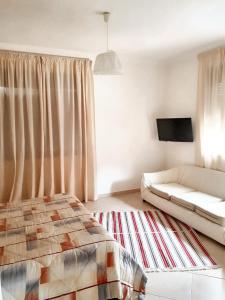 ein Wohnzimmer mit einem Bett und einem Sofa in der Unterkunft 3 bedrooms villa with private pool enclosed garden and wifi at Marrakech in Aït Ali
