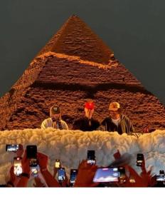 un grupo de personas tomando fotos de la pirámide en Falcon pyramids inn, en El Cairo