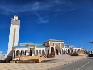 a large building with a clock tower in front of it at Appartement moderne près de la corniche in Nador