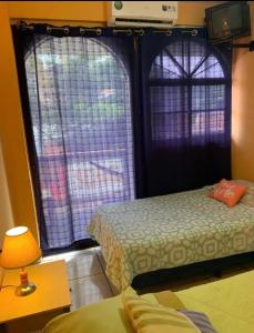 um quarto com duas camas e uma janela com cortinas em Hotel central em San Juan del Sur