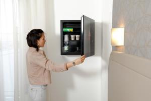 a woman is standing in front of a vending machine at Hotel Alexander in Milano Marittima