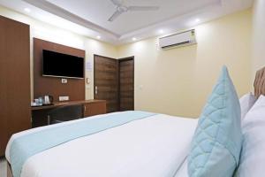 una camera con letto, scrivania e TV di Hotel Mannat at Paschim Vihar a Nuova Delhi
