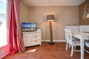ein Esszimmer mit einem Tisch und einem TV auf einer Kommode in der Unterkunft Noah - Sonnenhof 7 in Kellenhusen