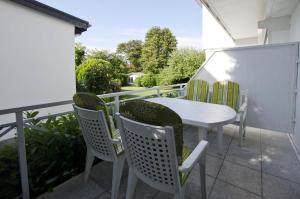 een patio met een tafel en stoelen op een balkon bij Noah - Sonnenhof 7 in Kellenhusen