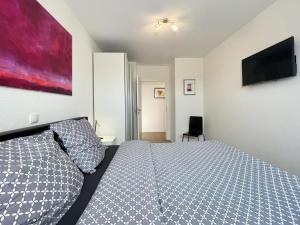 a bedroom with a bed and a tv on the wall at Quartier Hohe Geest 2 in Sahlenburg