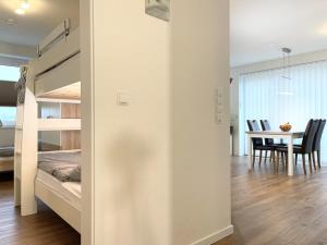 ein Schlafzimmer mit einem Etagenbett und ein Esszimmer mit einem Tisch in der Unterkunft Quartier Hohe Geest 19 in Cuxhaven