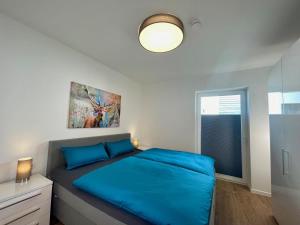 - une chambre avec un lit bleu et une fenêtre dans l'établissement Sonnenweg 46 - CARLA, à Heringhausen