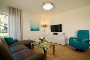 - un salon avec un canapé et une télévision dans l'établissement Sonnenweg 46 - CARLA, à Heringhausen