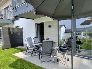 une terrasse avec une table, des chaises et un parasol dans l'établissement Sonnenweg 46 - SEESTERN, à Heringhausen