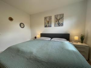 - une chambre avec un grand lit et 2 photos sur le mur dans l'établissement Sonnenweg 46 - SEESTERN, à Heringhausen