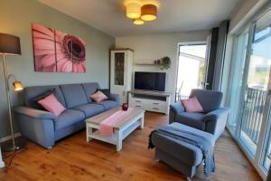 uma sala de estar com um sofá e uma televisão em Sonnenweg 42 em Heringhausen