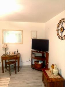 Paularo的住宿－casa spiz，客厅配有平面电视和桌子。