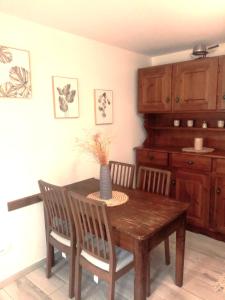 Paularo的住宿－casa spiz，餐桌,两把椅子,花瓶
