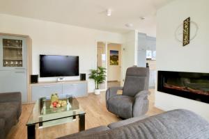 a living room with a couch and a tv at Haus Sonnendeck - Sonnenweg 21 in Heringhausen