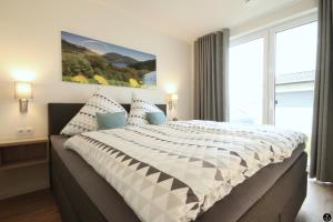 a bedroom with a large bed with a large window at Haus Sonnendeck - Sonnenweg 21 in Heringhausen