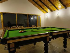 uma mesa de bilhar numa sala com afits em Hidden Trails Ramgarh, Nainital em Rāmgarh