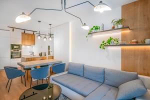 a living room with a blue couch and a table at Napfény Resort by HelloBalatonlelle in Balatonlelle