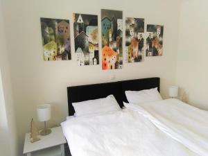 ein Schlafzimmer mit einem weißen Bett und einigen Bildern an der Wand in der Unterkunft Sonnenweg 17 in Diemelsee