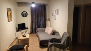 een woonkamer met een bank en een tv bij Anna's house in Epanomi