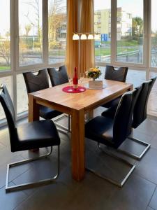 a dining room table with black chairs around it at Leuchtturm 4 in Großenbrode