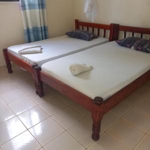 two twin beds sitting next to each other in a room at Zaradise Suites in Mombasa