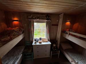 a bedroom with two bunk beds and a window at Strandhytte nær preikestolen in Strand