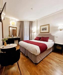 ローマにあるAffittacamere Boncompagni Suiteの大きなベッドとテーブルが備わるホテルルームです。