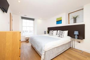 a bedroom with a large bed and a flat screen tv at ALTIDO Splendid 2-BR Flat near Edinburgh Castle in Edinburgh