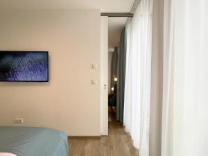 um quarto com uma cama e um corredor com cortinas brancas em Nino 17 em Nordhorn