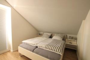 a small bedroom with a bed in a attic at Sonnengarten 20 - Heimathafen in Kellenhusen