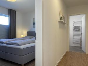 um pequeno quarto com uma cama e uma porta em Diemelblick 12 - LENI em Heringhausen