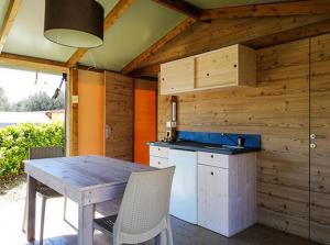 uma cozinha em madeira com uma mesa e um fogão em Villaggio Residence Villamarina em Marina di Camerota