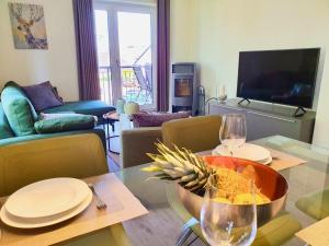 soggiorno con tavolo e ciotola di cibo e bicchieri da vino di Kapitänshaus 3 a Kellenhusen