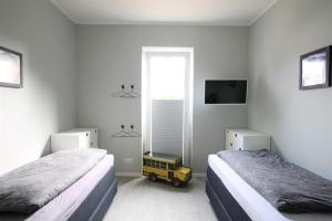 a bedroom with two beds and a yellow cart in it at Sonnengarten 3 - KüstenART in Kellenhusen
