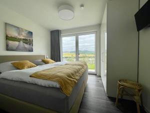 ein Schlafzimmer mit einem großen Bett und einem großen Fenster in der Unterkunft Ferienhaus SONNENWEG 8 in Heringhausen
