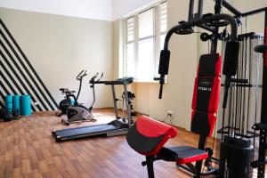 een fitnessruimte met verschillende loopbanden en een rode stoel bij Hotel Polonia Centrum in Wrocław