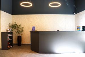 a lobby with a counter with lights above it at Hotel Polonia Centrum in Wrocław