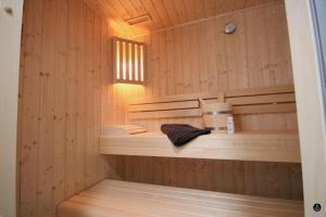 a sauna with wooden walls and a towel on a shelf at Sonnengarten 11 in Kellenhusen