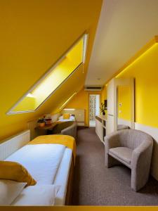 a hotel room with two beds and a skylight at Hotel Mayer Alsóörs in Alsóörs