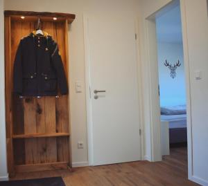 Una habitación con una puerta con una chaqueta colgada. en Haus Seeblick - Sonnenweg 14, en Diemelsee