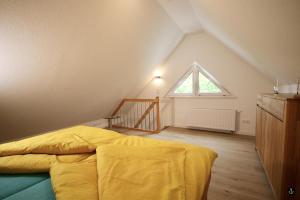 ein Schlafzimmer mit einem gelben Bett und einem Fenster in der Unterkunft Blankwasser 8 in Grömitz