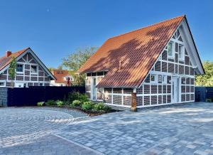 a house with a metal roof and a brick driveway at Ferienhaus am Angerplatz in Cuxhaven