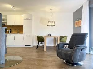 ein Wohnzimmer mit einem Stuhl und einem Tisch in der Unterkunft Kirschgarten 3 in Kellenhusen