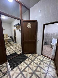 シムケントにあるКоттедж Darinaのバスルーム(トイレ付)、木製のドアが備わります。