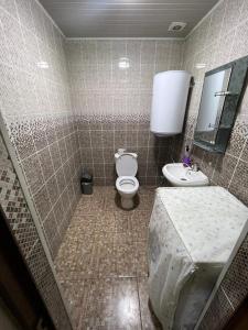 シムケントにあるКоттедж Darinaのタイル張りのバスルーム(トイレ、シンク付)